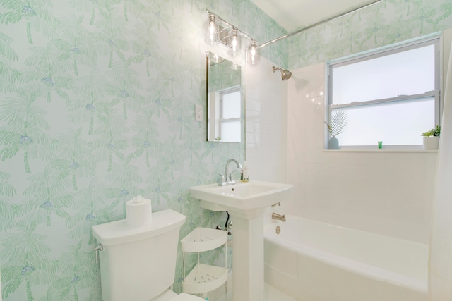 full bathroom with tiled shower / bath, plenty of natural light, and toilet