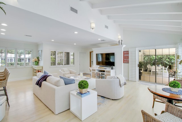 living room with vaulted ceiling with beams, a wealth of natural light, and light wood-type flooring