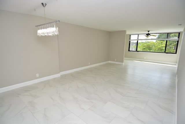 unfurnished room with ceiling fan with notable chandelier