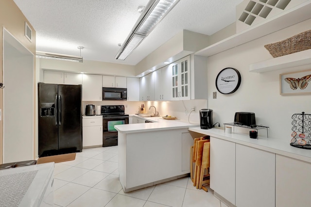 kitchen featuring kitchen peninsula, a textured ceiling, sink, black appliances, and white cabinetry