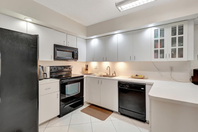 kitchen with black appliances, sink, light tile patterned floors, a textured ceiling, and white cabinetry