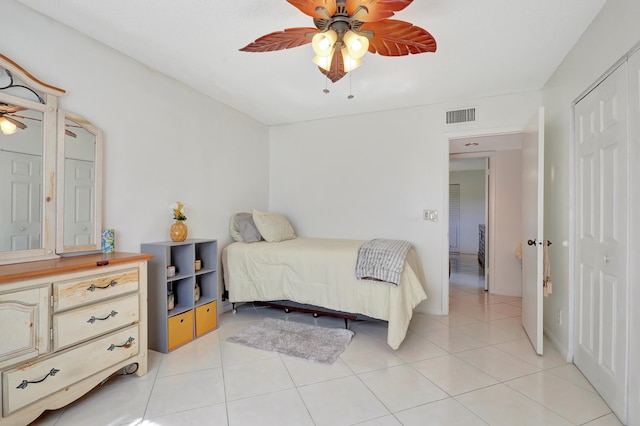 bedroom featuring ceiling fan, a closet, and light tile patterned flooring