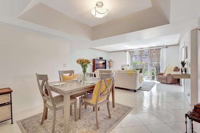 tiled dining area featuring a tray ceiling