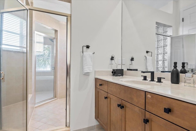 bathroom featuring a shower with shower door, vanity, and tile patterned flooring