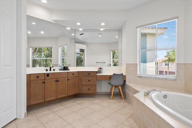 bathroom with tile patterned floors, vanity, and tiled bath