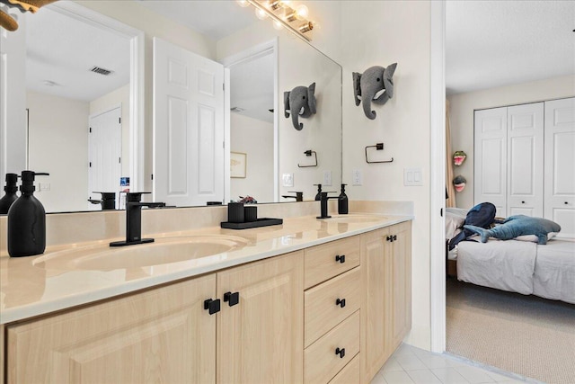 bathroom with double sink vanity and tile patterned flooring