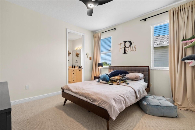 bedroom featuring ensuite bathroom, carpet, and ceiling fan