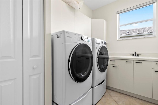 washroom featuring sink, separate washer and dryer, cabinets, and light tile patterned floors