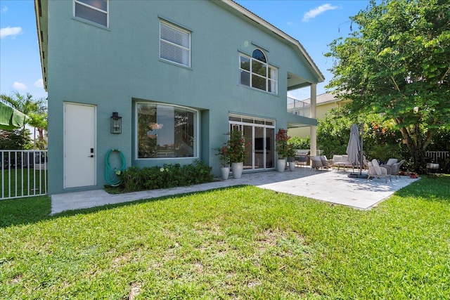 rear view of house with a yard and a patio area