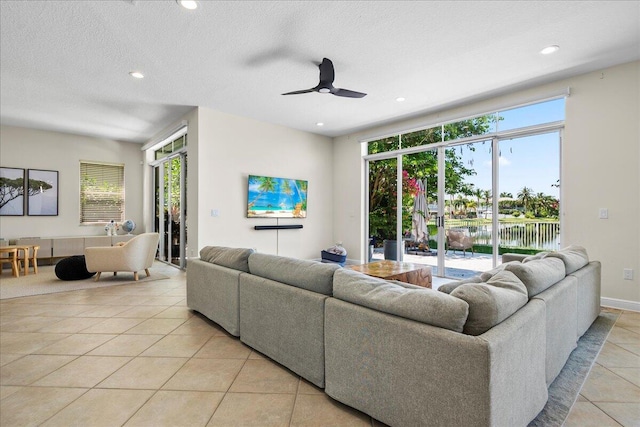 tiled living room featuring a textured ceiling and ceiling fan