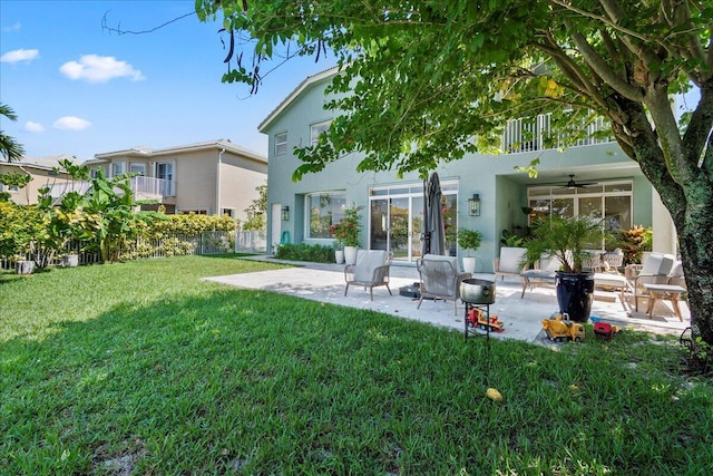 rear view of house featuring a yard, ceiling fan, and a patio area