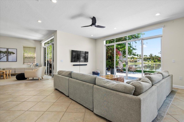 tiled living room featuring a textured ceiling and ceiling fan