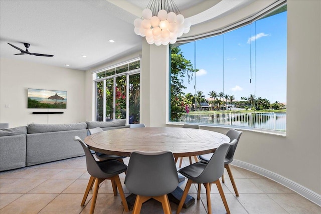 dining space with tile patterned floors, a water view, and plenty of natural light