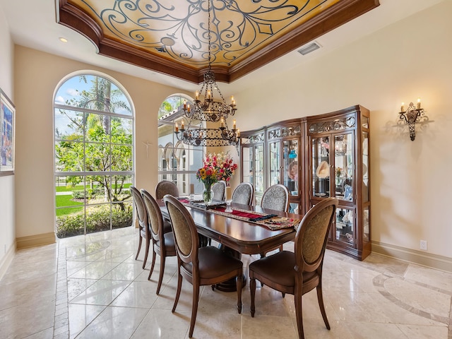 tiled dining space with ornamental molding, a raised ceiling, and a chandelier