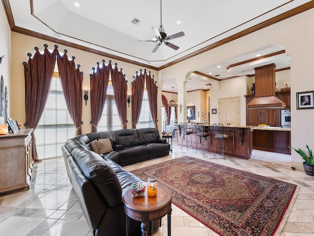 living room with light tile patterned flooring, crown molding, ceiling fan, and a raised ceiling