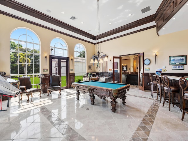 game room with billiards, a high ceiling, ornamental molding, light tile patterned floors, and bar area