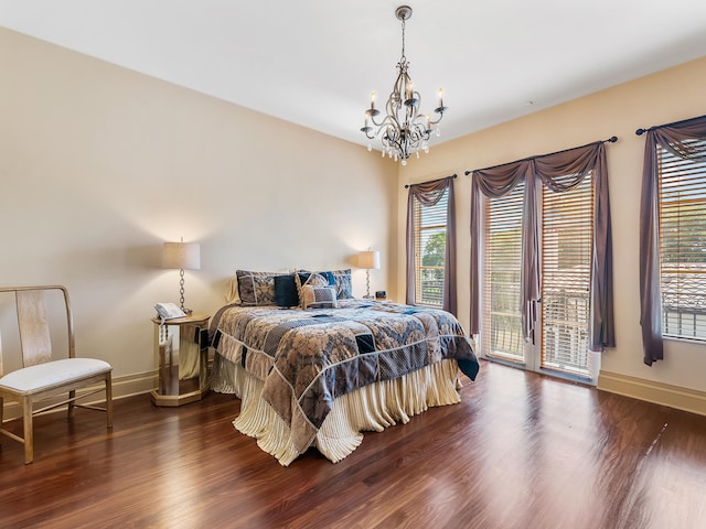 bedroom with an inviting chandelier, access to outside, and dark hardwood / wood-style floors