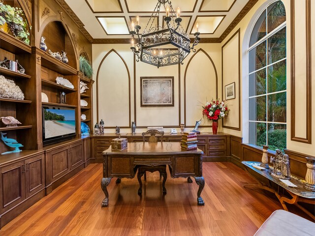 office space with wood-type flooring, crown molding, coffered ceiling, and a chandelier