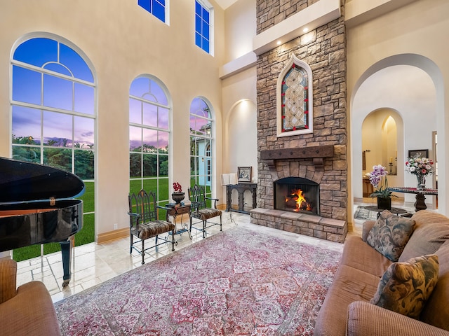 living room featuring a fireplace, tile patterned flooring, and a towering ceiling