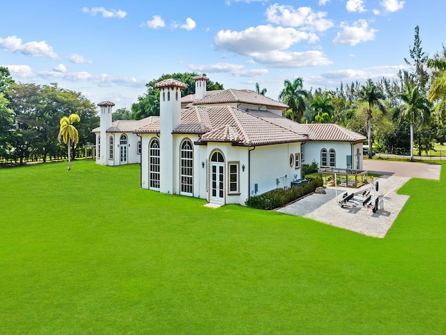 rear view of house with a patio and a yard