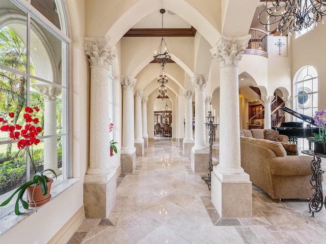 tiled living room featuring a fireplace, a chandelier, and a towering ceiling