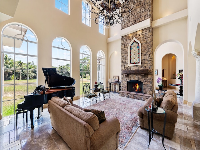 living room featuring an inviting chandelier, a fireplace, tile patterned flooring, and a towering ceiling