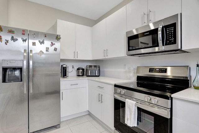 kitchen with white cabinets, appliances with stainless steel finishes, and light tile patterned floors