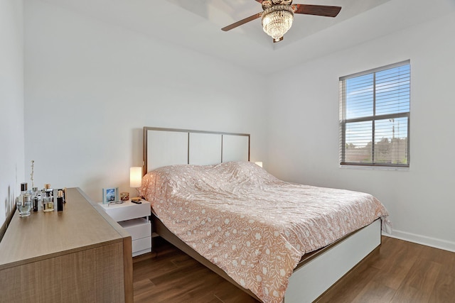 bedroom with dark hardwood / wood-style flooring and ceiling fan