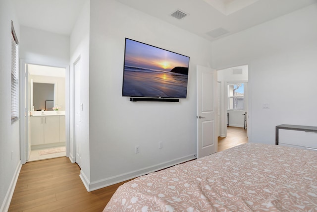 unfurnished bedroom featuring connected bathroom and light hardwood / wood-style floors