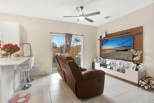 living room with bar, light tile patterned floors, and ceiling fan