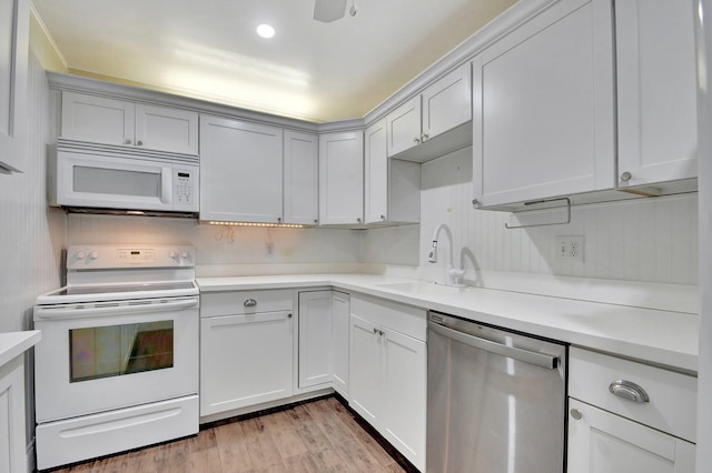 kitchen with sink, white appliances, and light wood-type flooring