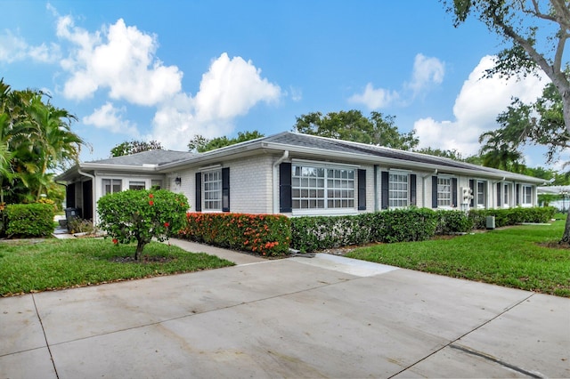 single story home with a front yard and brick siding