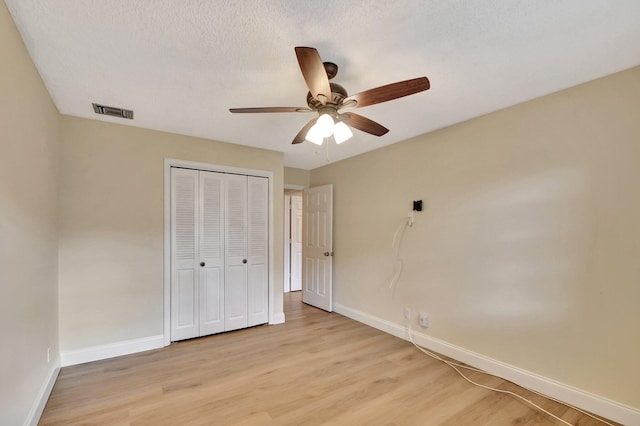 unfurnished bedroom featuring ceiling fan, a closet, and light hardwood / wood-style floors