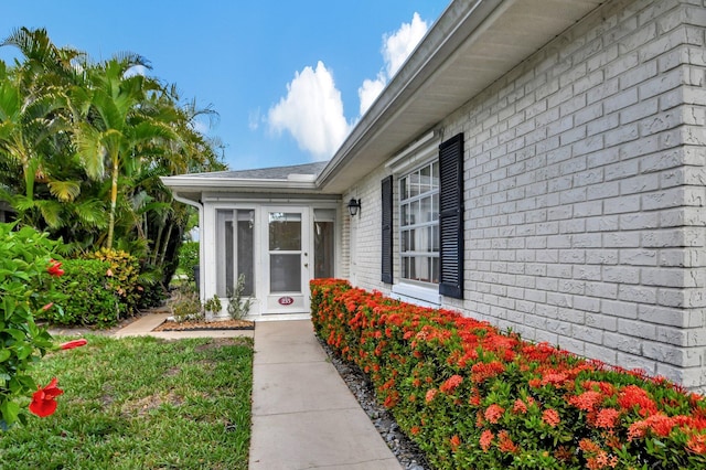 doorway to property with brick siding