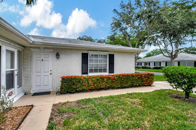 property entrance featuring a lawn