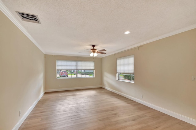 spare room with crown molding, a healthy amount of sunlight, a textured ceiling, and light wood-type flooring