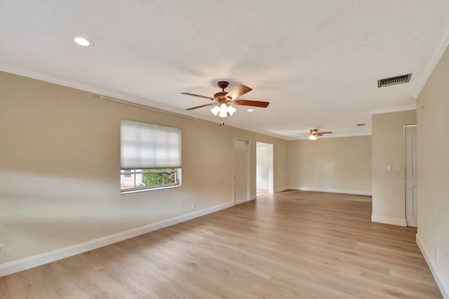 empty room featuring a textured ceiling, light hardwood / wood-style flooring, ceiling fan, and crown molding