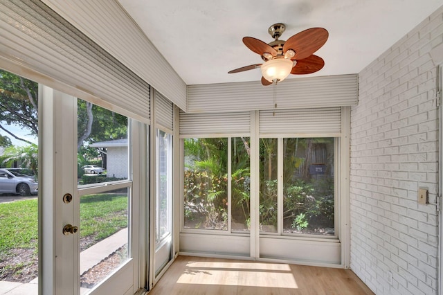 unfurnished sunroom with ceiling fan