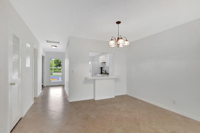 unfurnished living room with sink, light tile patterned floors, and a chandelier