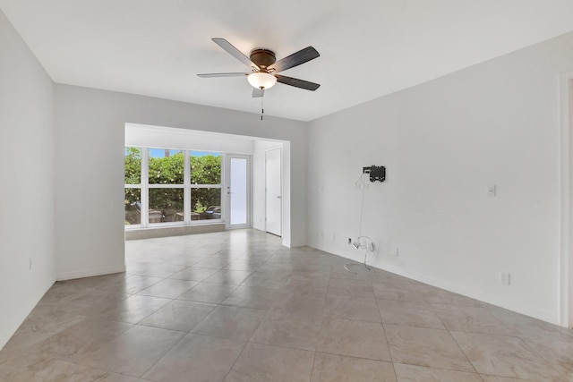 tiled spare room featuring ceiling fan