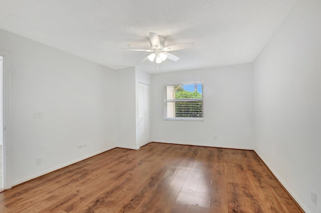 empty room with hardwood / wood-style flooring and ceiling fan