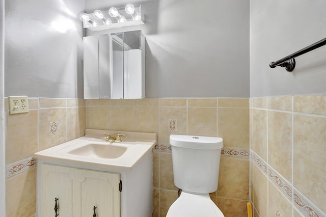 bathroom featuring vanity, decorative backsplash, tile walls, and toilet