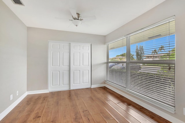 unfurnished bedroom with ceiling fan, hardwood / wood-style flooring, and a closet