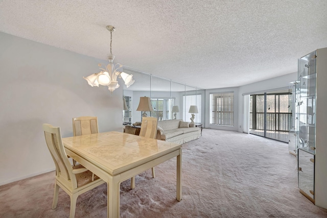 carpeted dining area featuring plenty of natural light, a chandelier, and a textured ceiling