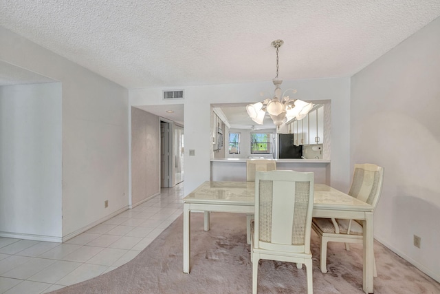 dining area featuring a textured ceiling, a notable chandelier, and light tile patterned flooring