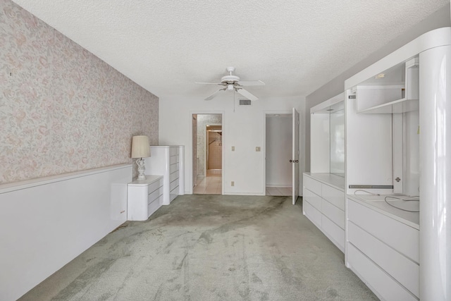 interior space with a textured ceiling and ceiling fan