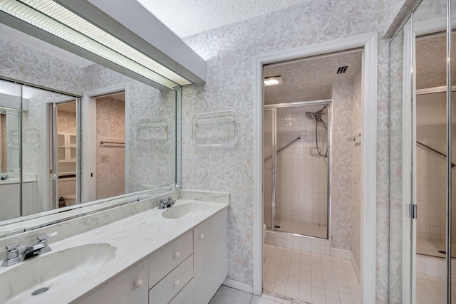 bathroom with tile patterned floors, an enclosed shower, vanity, a textured ceiling, and toilet