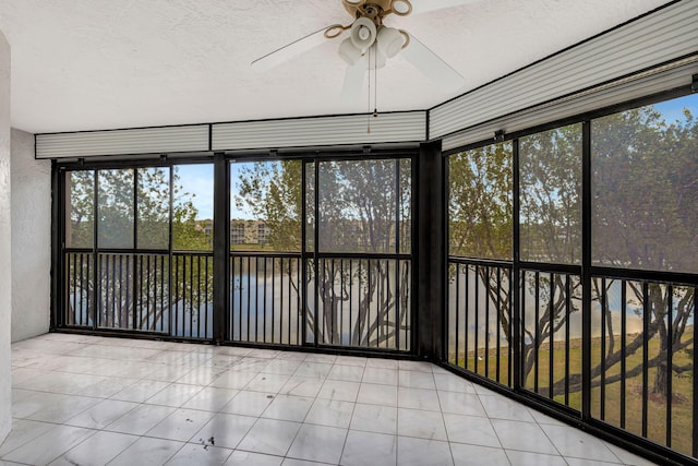 unfurnished sunroom with a water view and ceiling fan