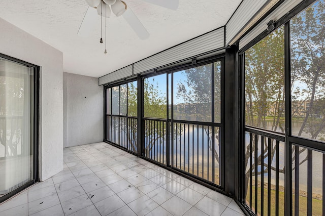 unfurnished sunroom with ceiling fan