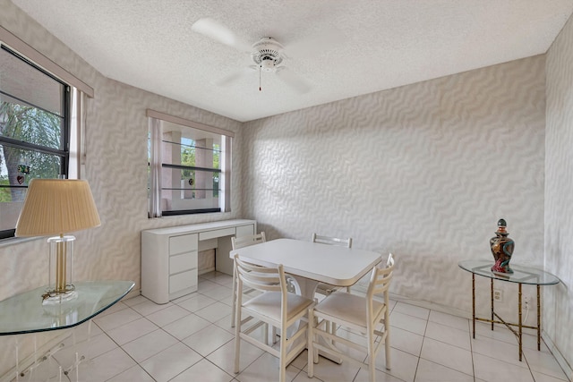 tiled dining space with ceiling fan and a textured ceiling